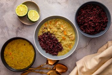 Thai green curry served with a mix of jasmine and black rice, with limes on the side